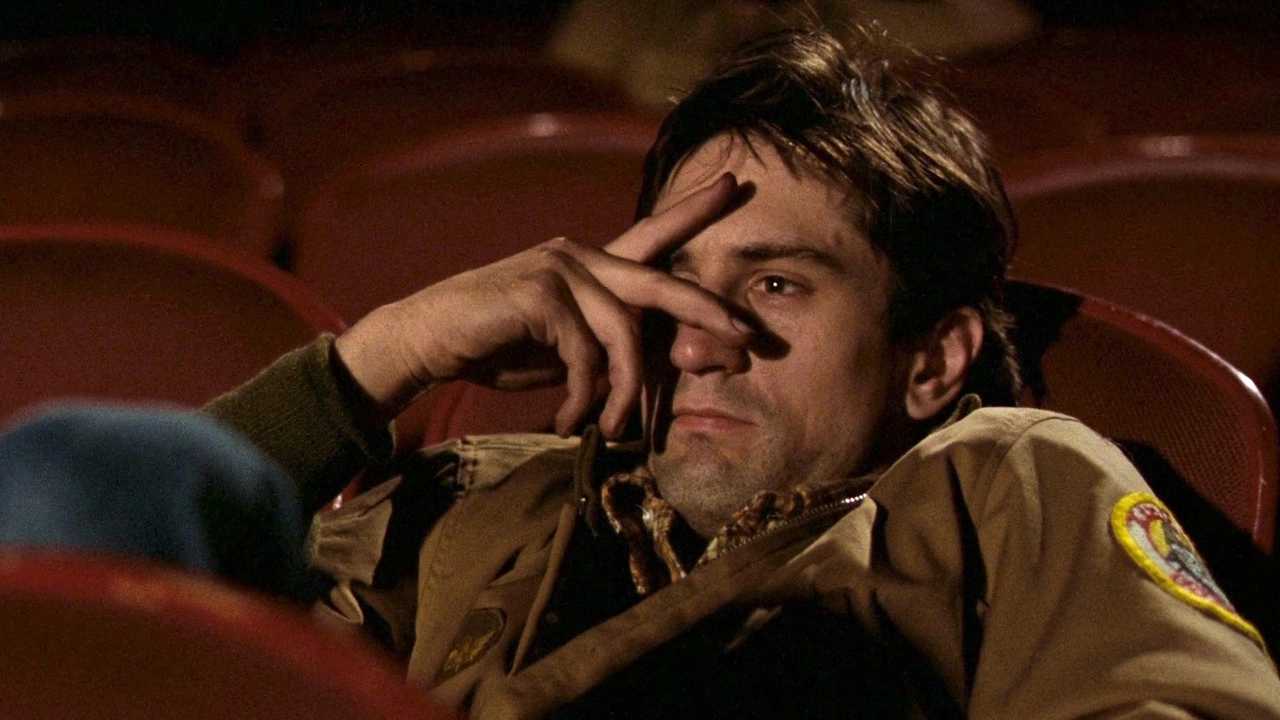 Captura de Taxi Driver: Travis Bickle en una butaca de cine, con la mano casi tapando sus ojos